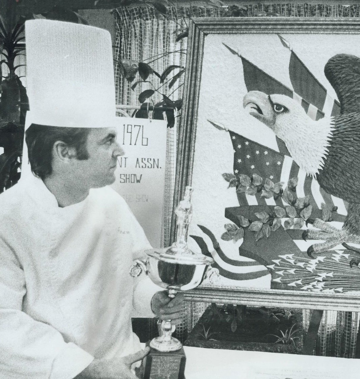 Pastry chef Alfred Leitch holding his trophy beside his award-winning chocolate bald eagle sculpture